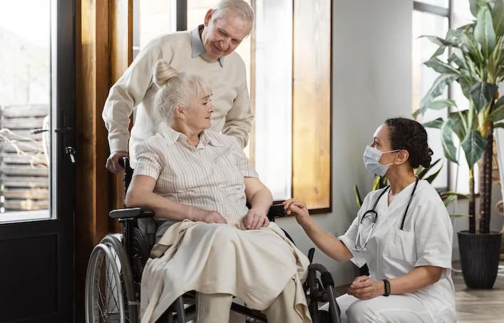 Caregiver providing senior home care services to elderly couple